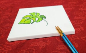 A painting canvas with half a painting and paint brushes